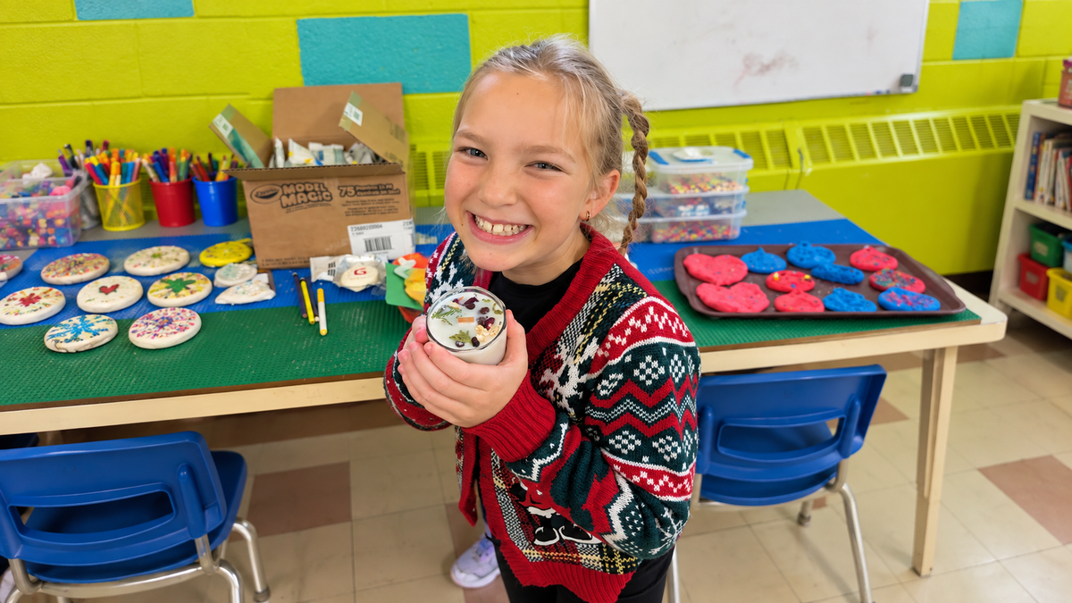 Jeune participante fière de sa chandelle fabriquée lors d’un atelier MA Création Écolo