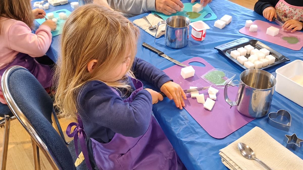 eune participante préparant des morceaux de base de savon lors d’un atelier de fabrication